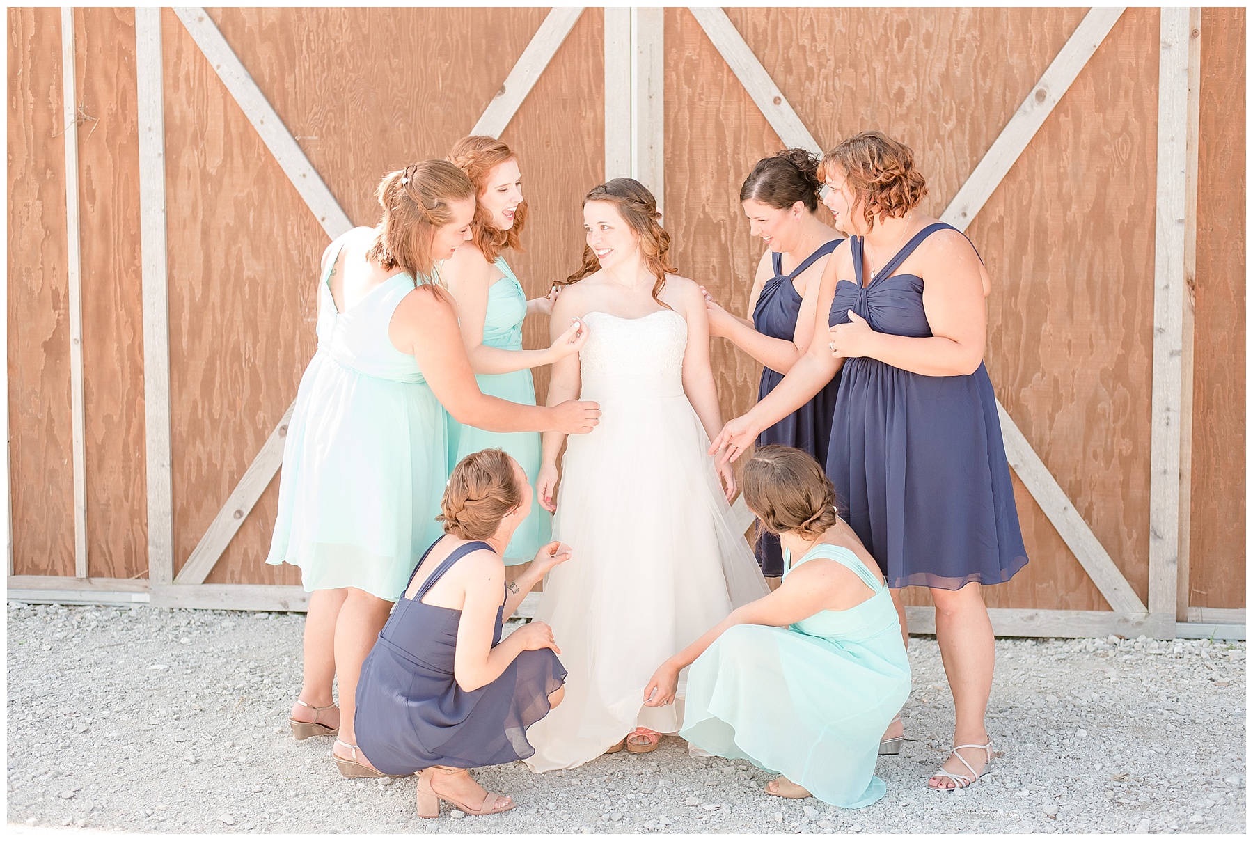 Bride surrounded by bridesmaids in navy and teal bridesmaids dresses in the 2018 wedding photography favorites