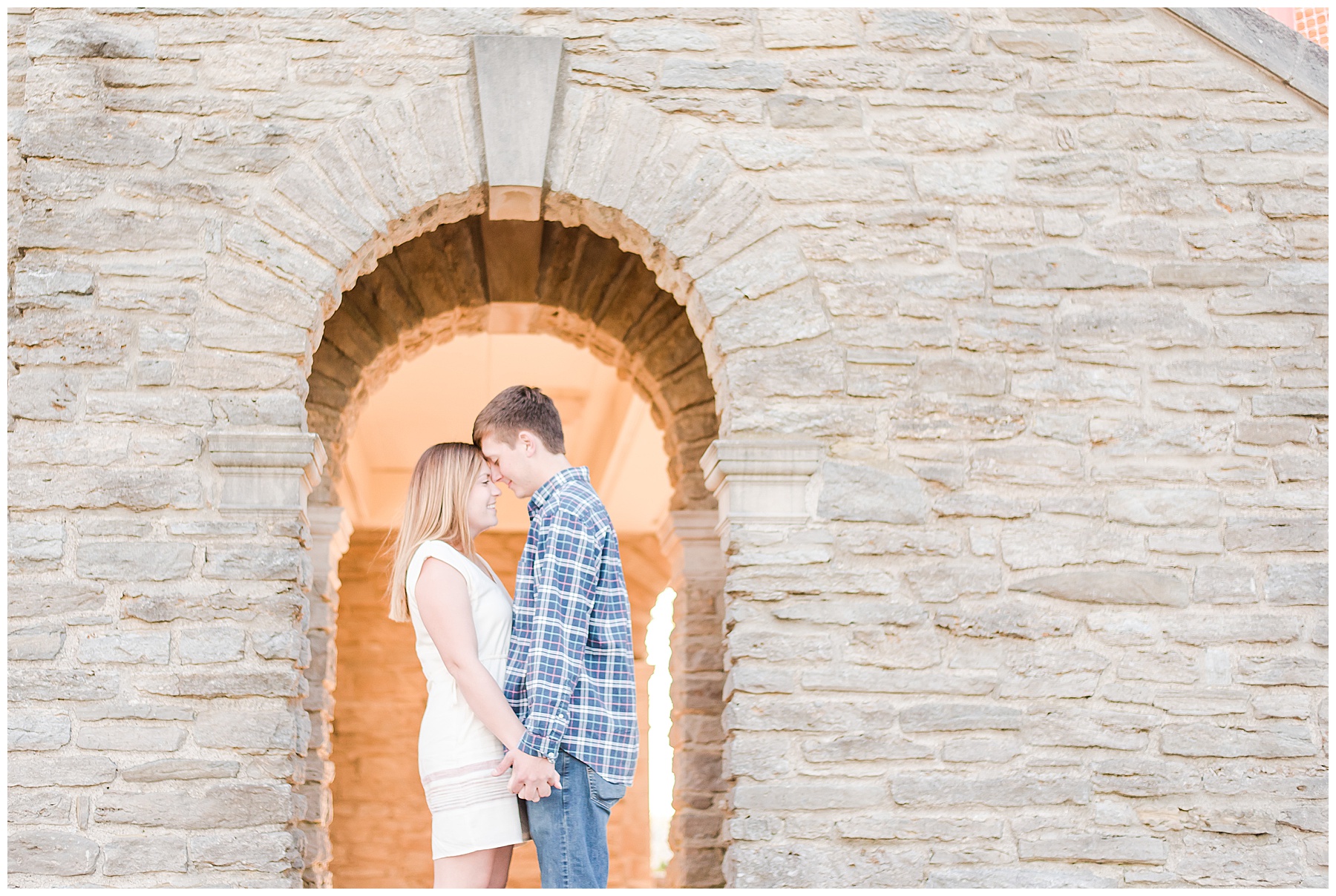 Bride and Groom standing chest to chest under an arch at Alms Park