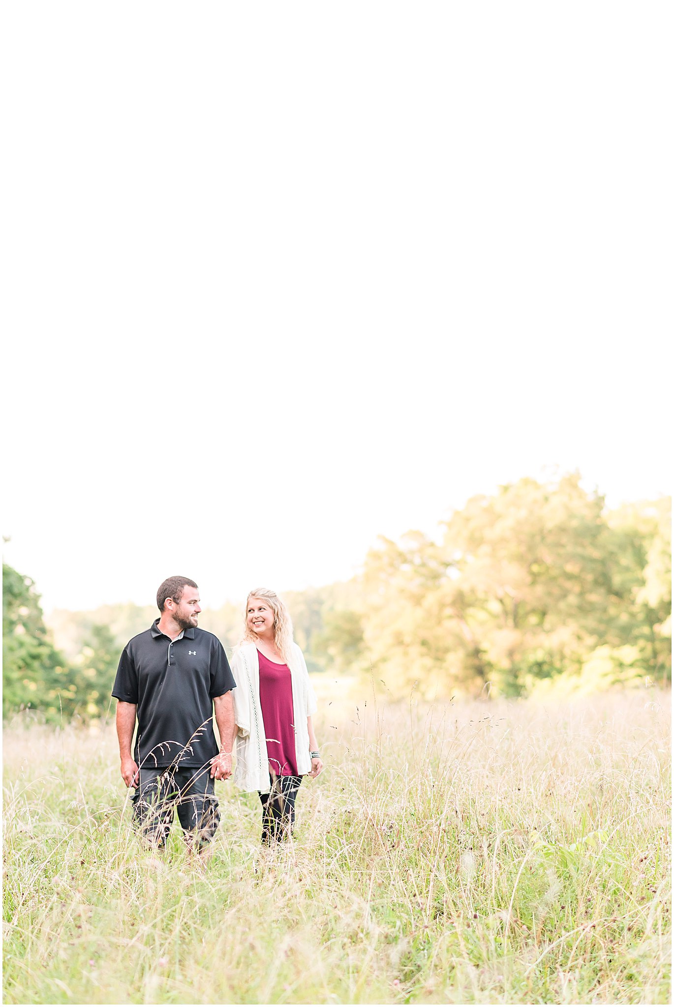 Bloomfield Indiana engagement session guy and girl standing in field smiling at each other