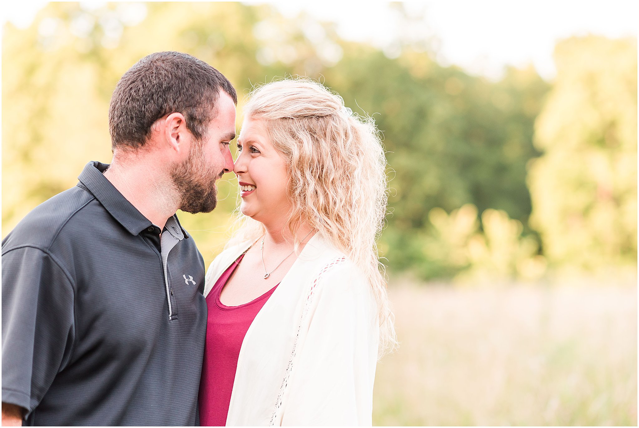 Bloomfield Indiana engagement session in field with guy and girl standing nose to nose