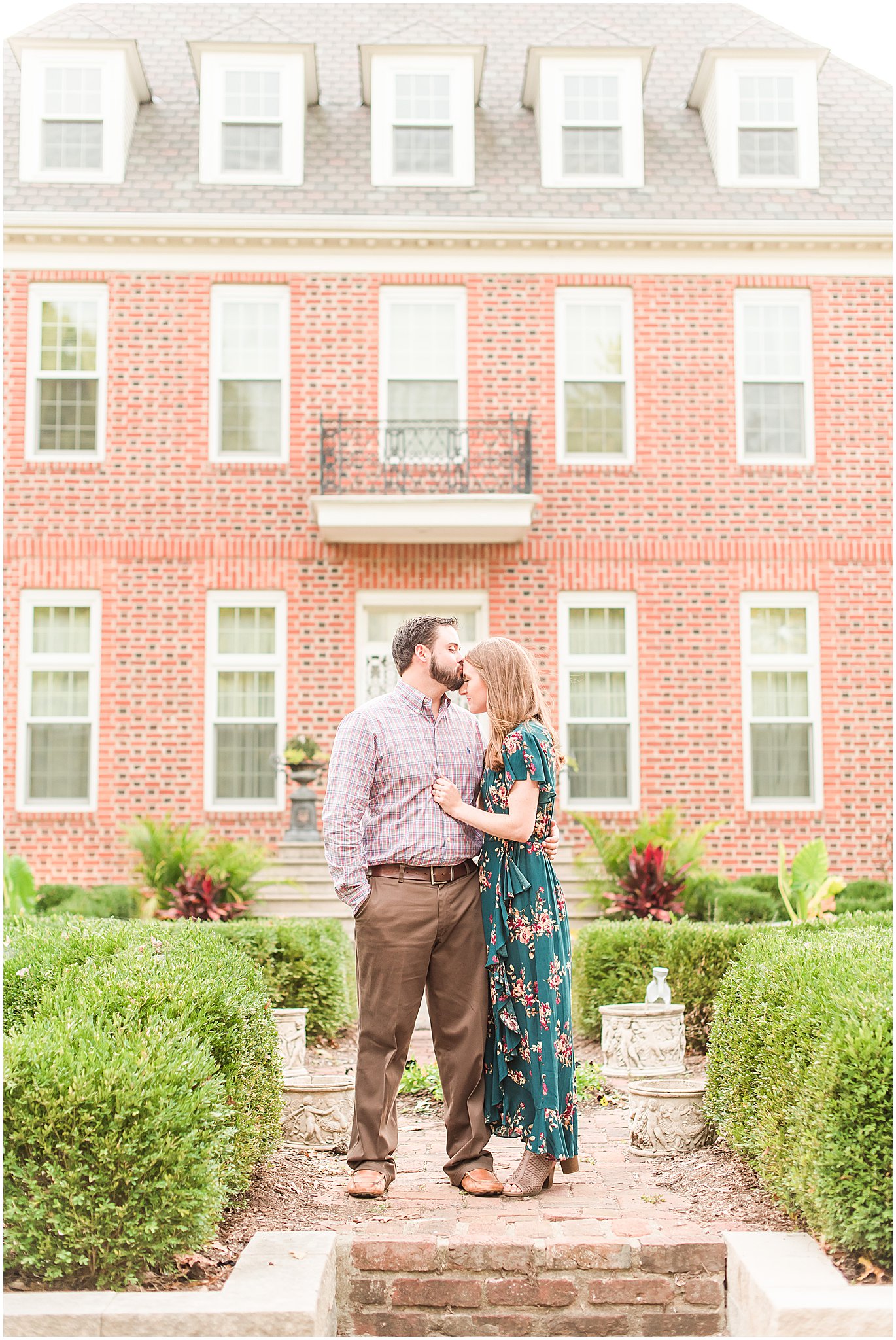 Groom kissing bride's forehead during Coxhall Gardens engagement session