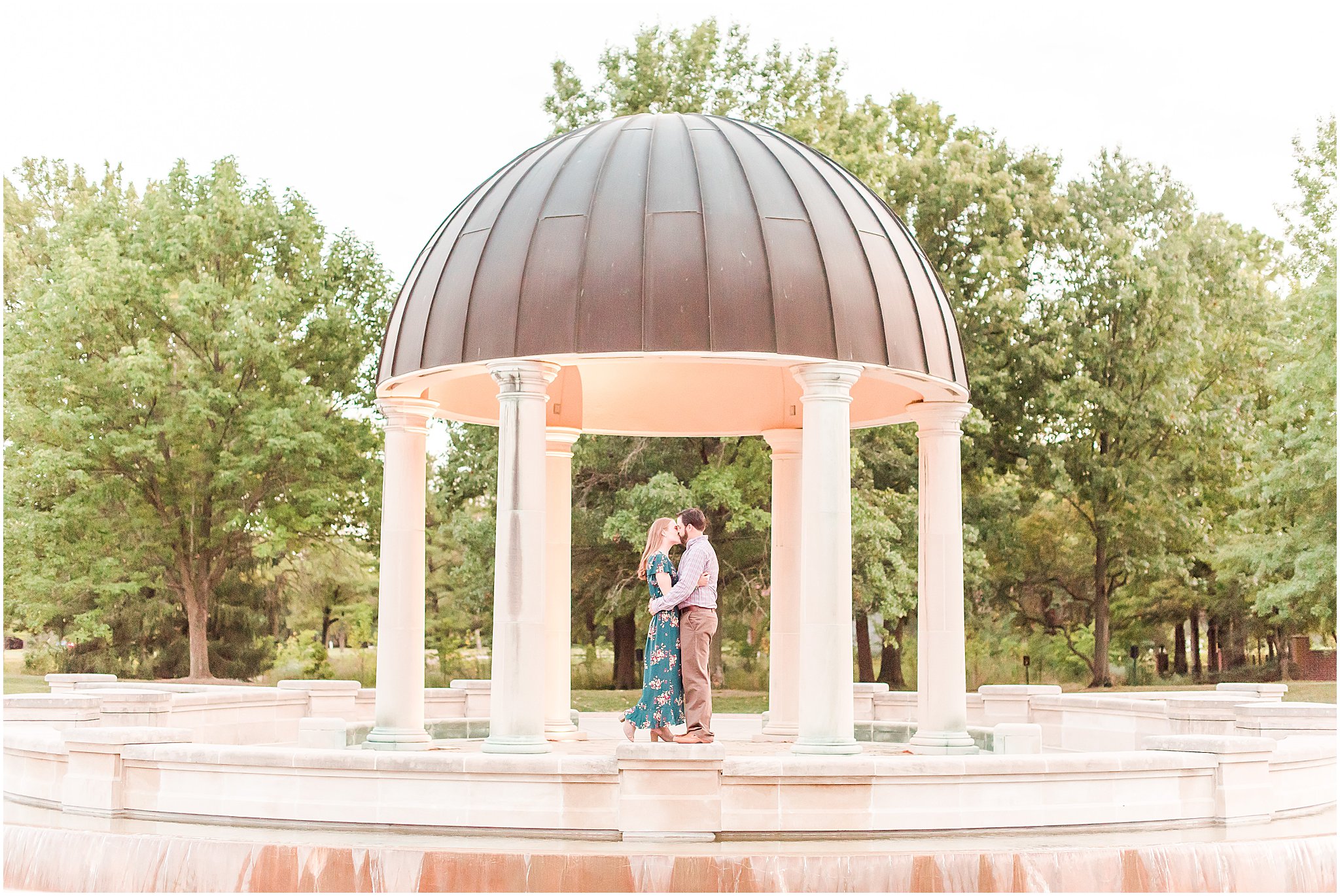 Bride and groom kissing under gazebo during Coxhall Gardens engagement session