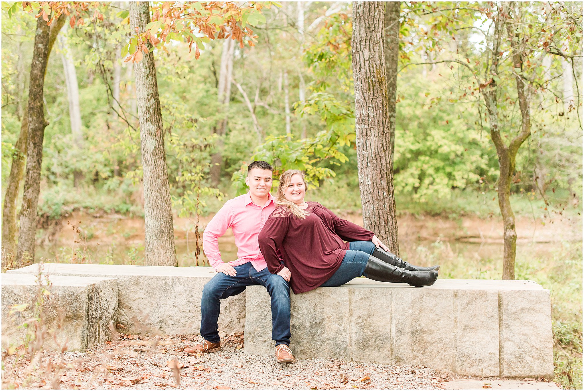 Couple sitting on bench and smiling during Beckley Creek Park engagement session