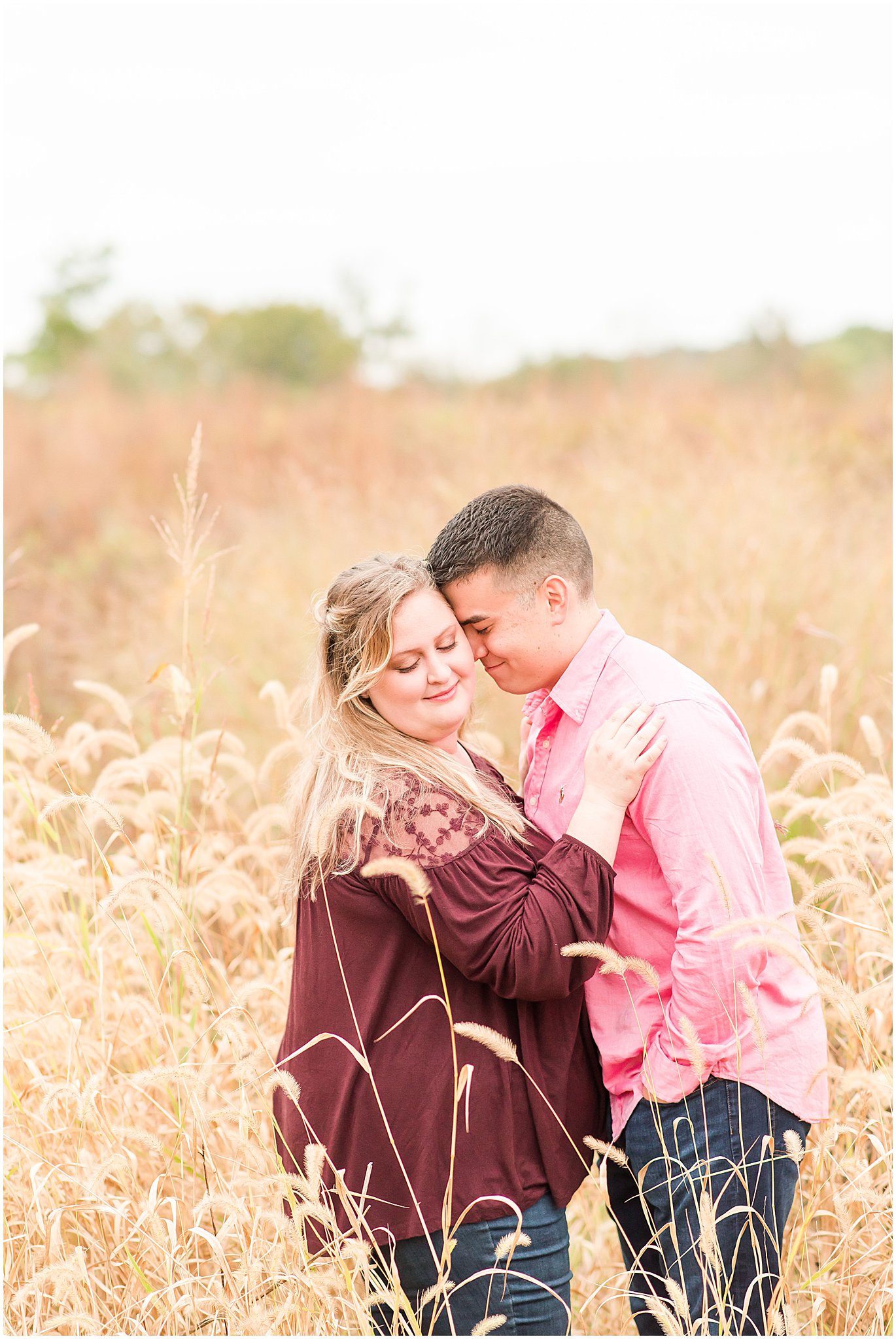 Couple nuzzling in field during Beckley Creek Park engagement session