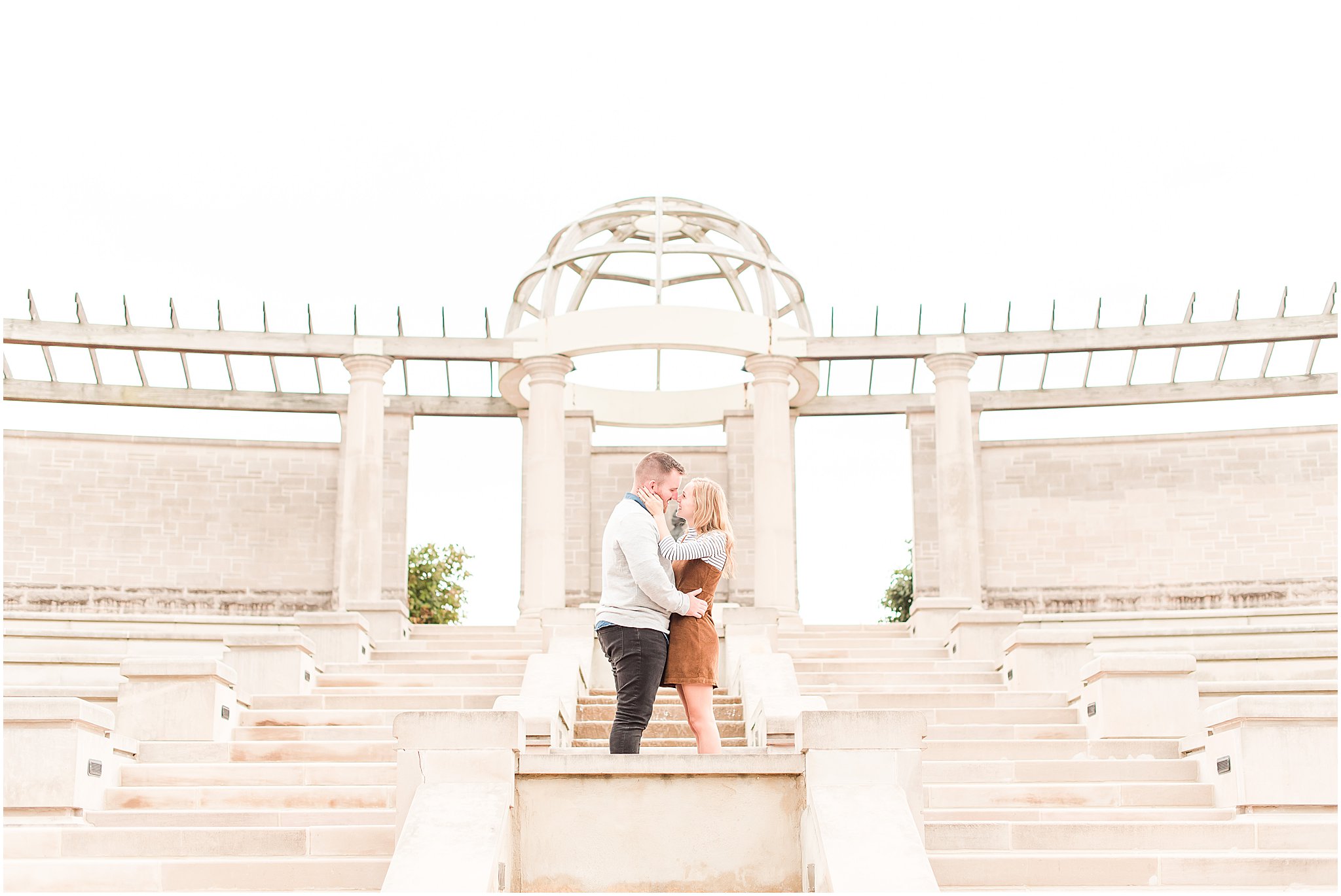 Couple smiling nose to nose in ampitheater at Coxhall Gardens engagement session
