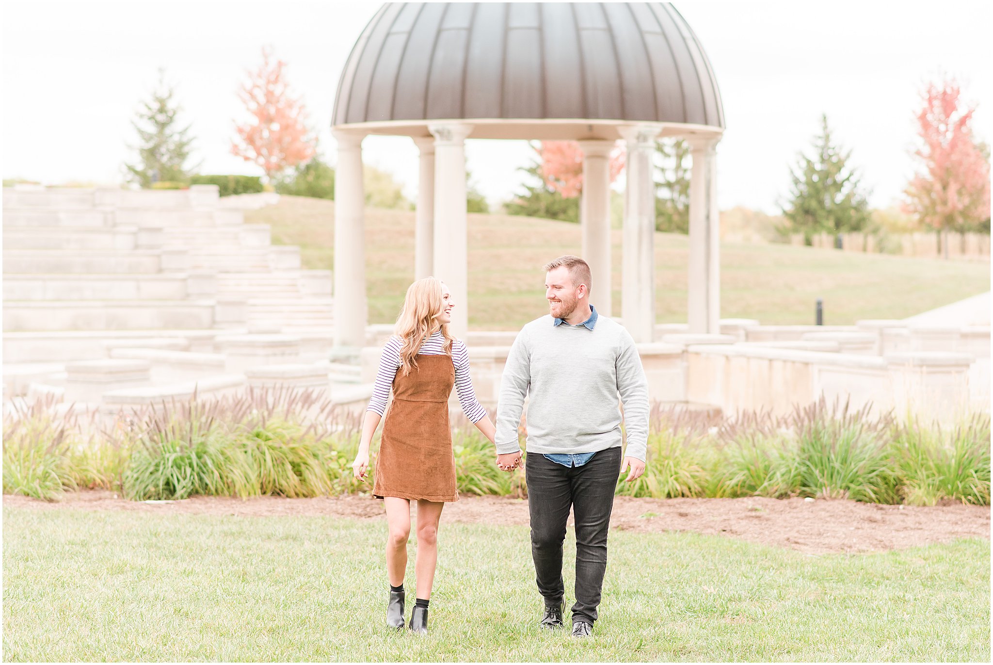 Couple walking in front of ampitheater during Coxhall Gardens engagement session