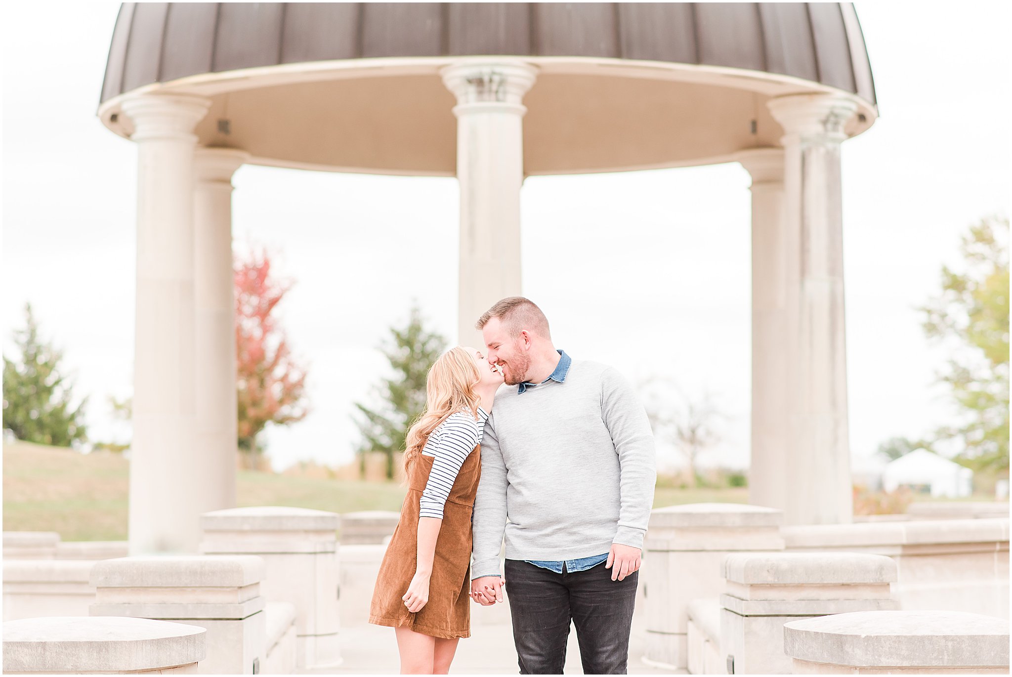Couple laughing right before they kiss during Coxhall Gardens engagement session