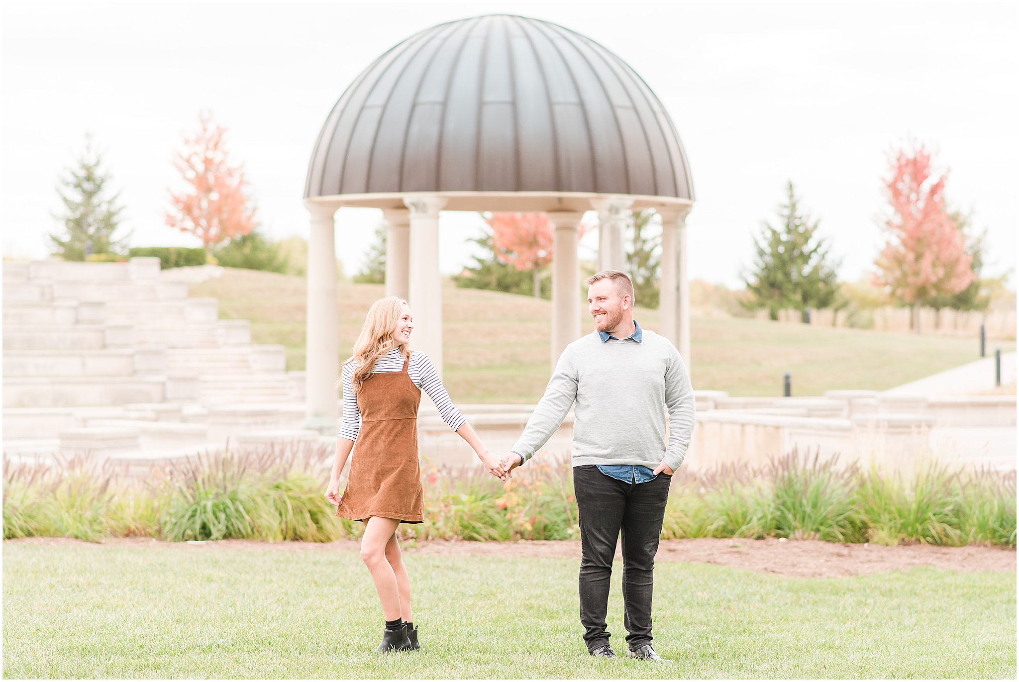 Couple holding hands and smiling during Coxhall Gardens engagement session