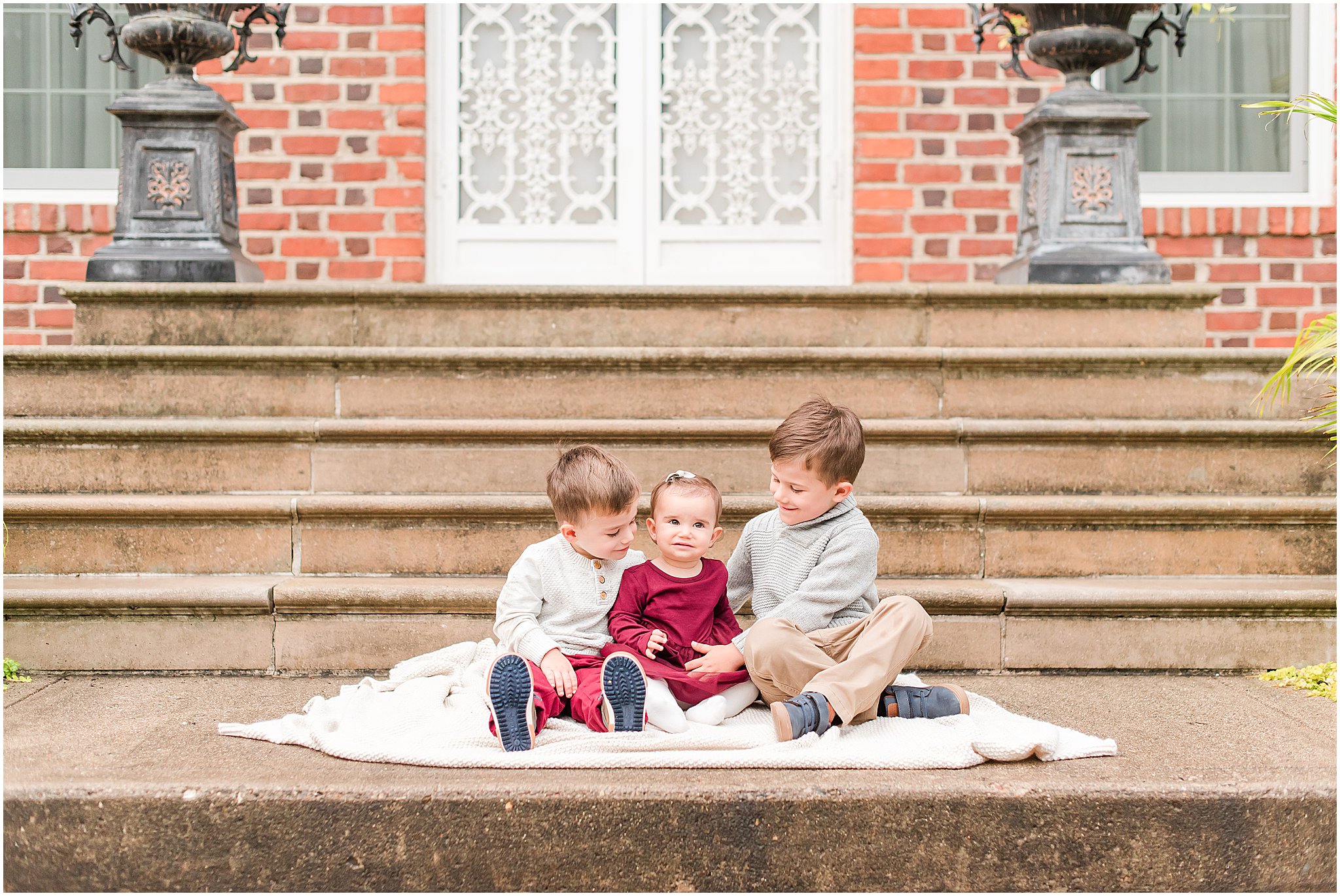 Three toddlers smiling at camera during Coxhall Gardens family session
