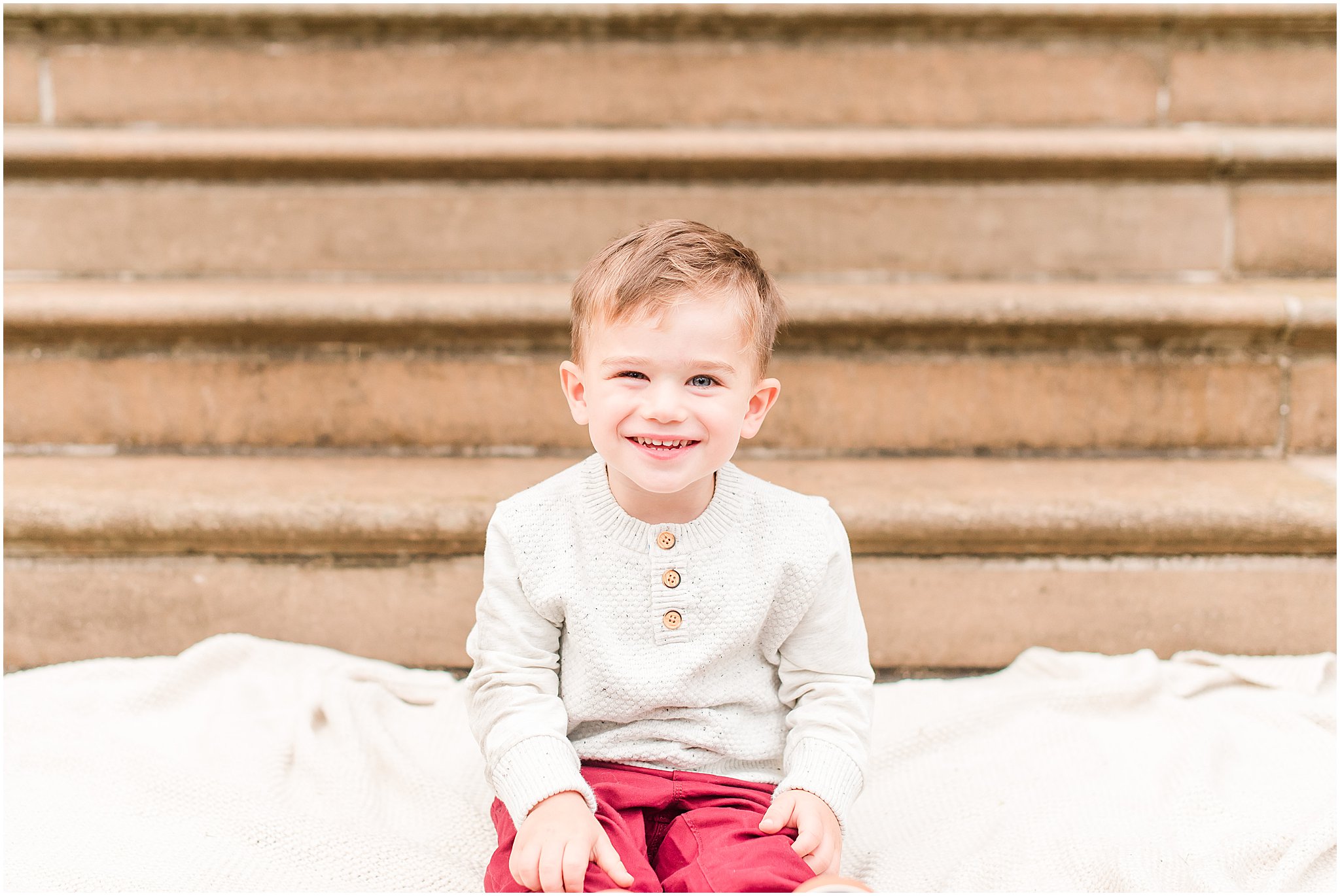 Toddler boy smiling at camera during Coxhall Gardens family session