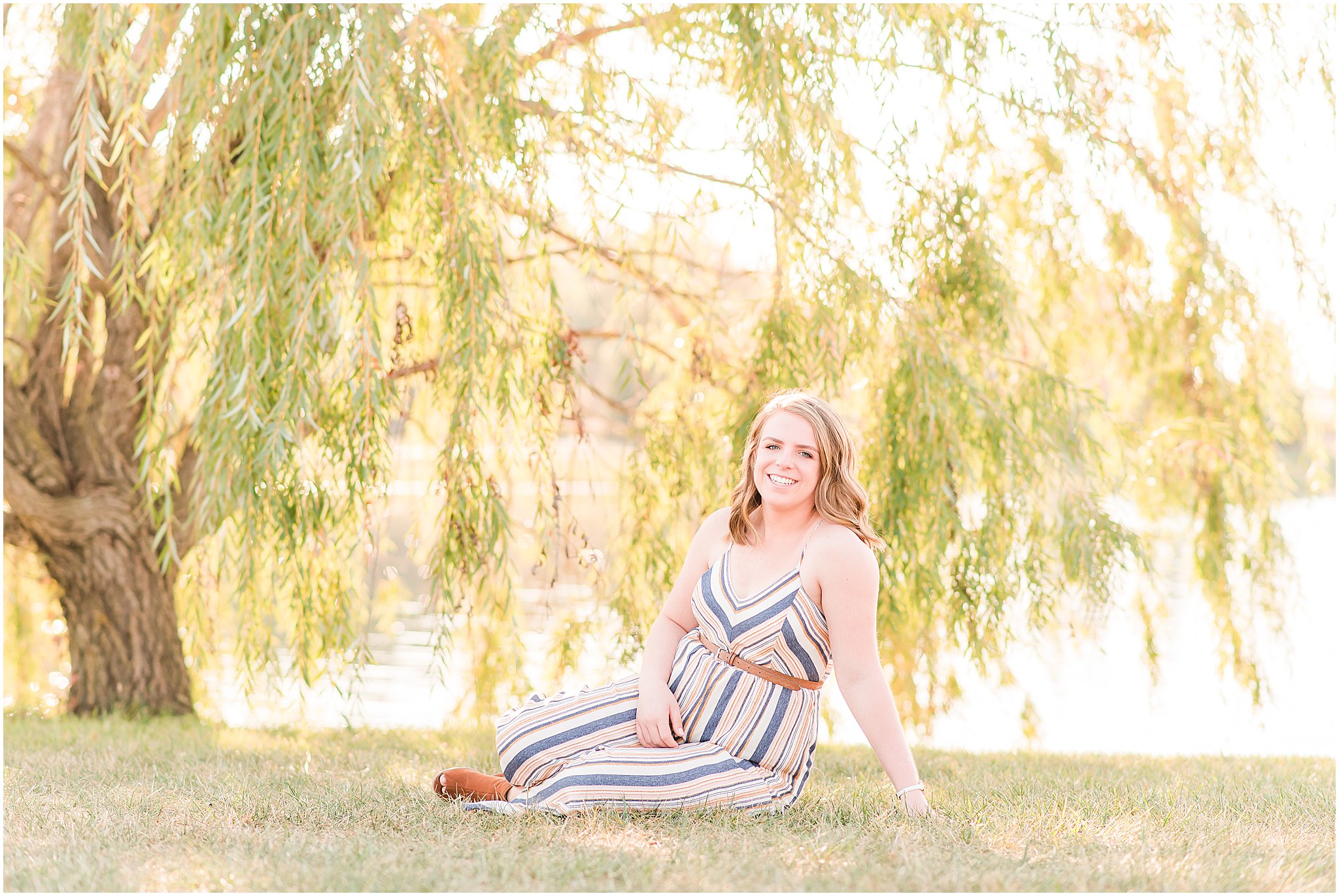 Girl sitting and smiling at camera during Coxhall Gardens senior session