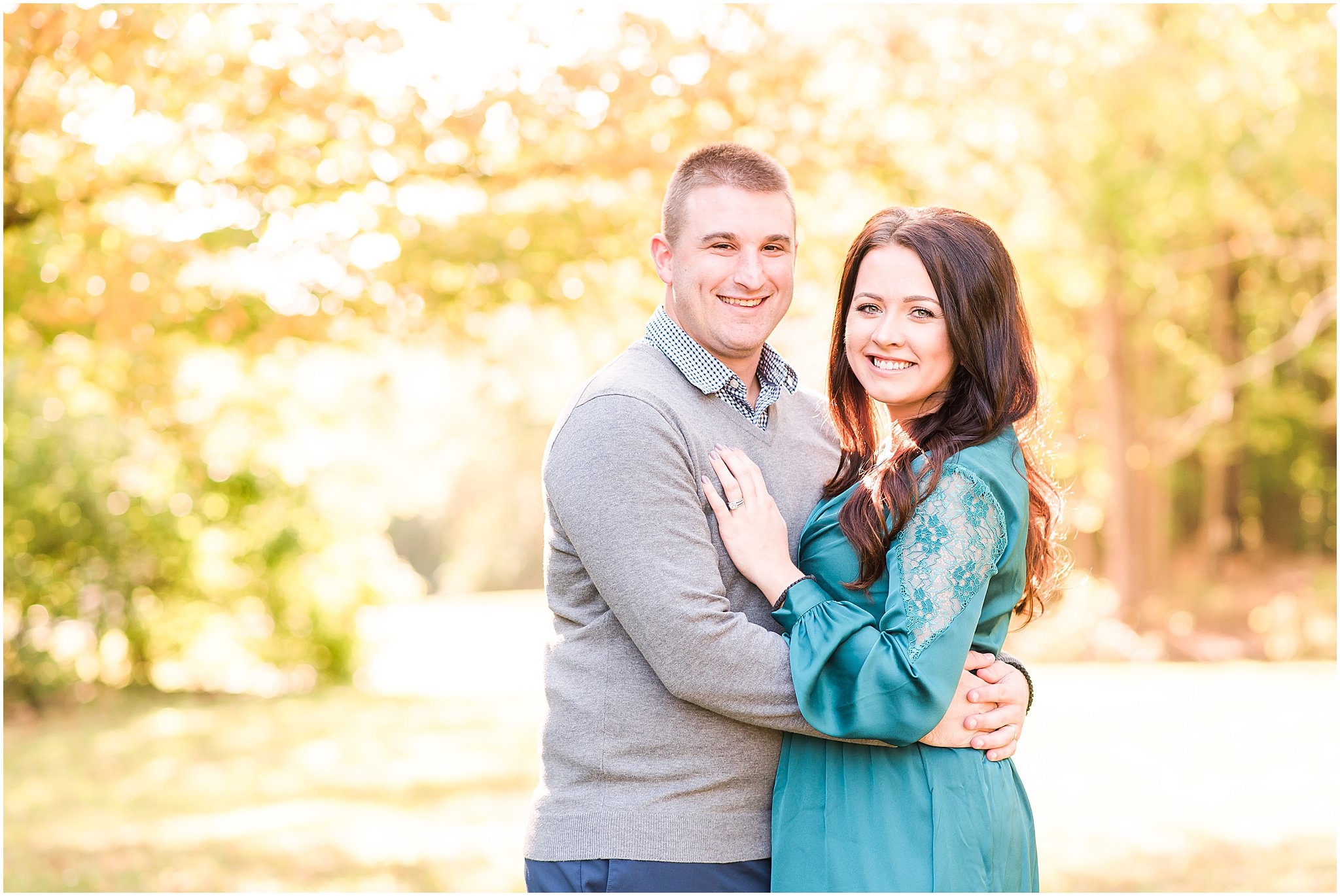 Man and woman in teal dress smiling at camera during Eagle Creek Park couples session