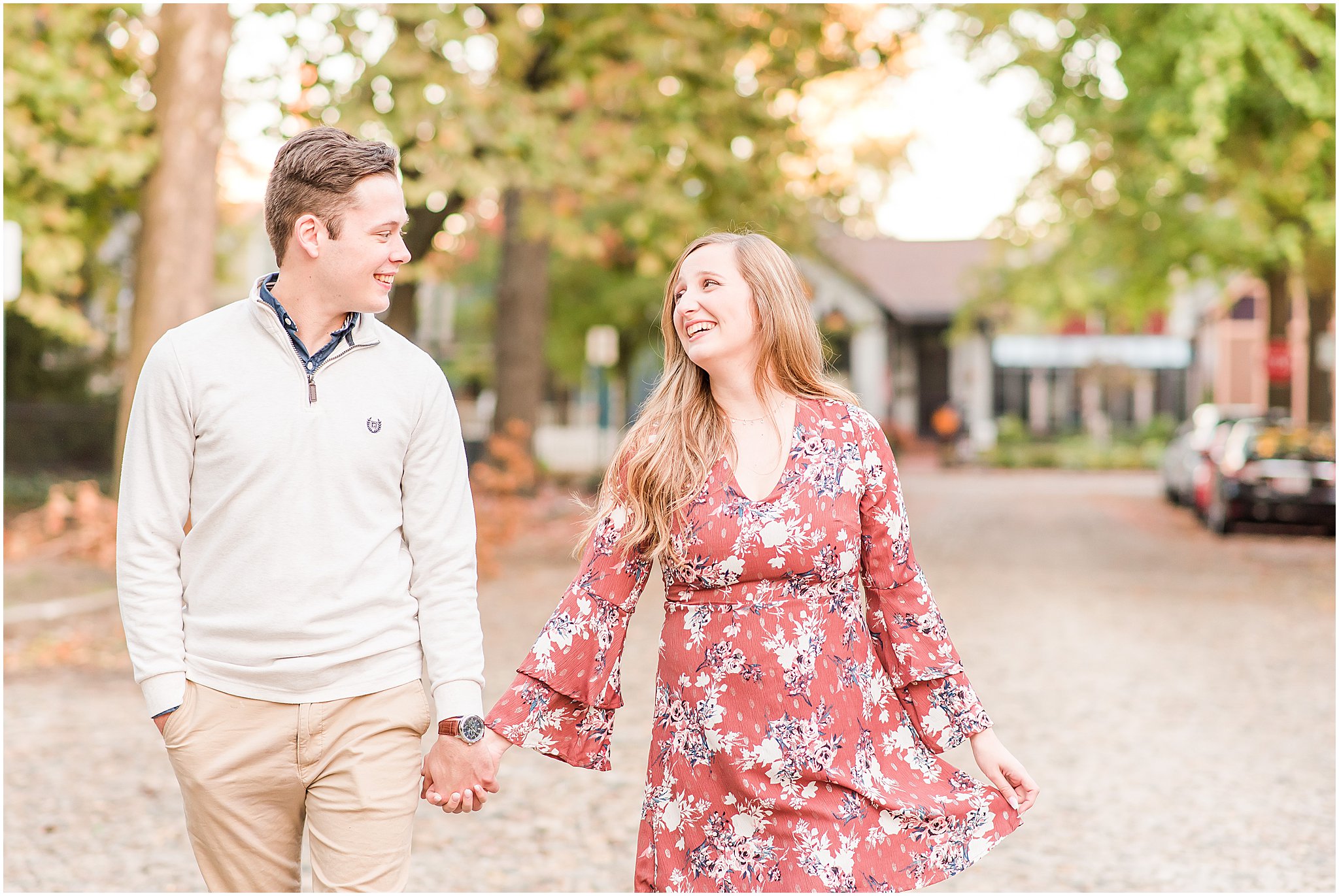Couple walking at laughing at each other during Lockerbie Square engagement session