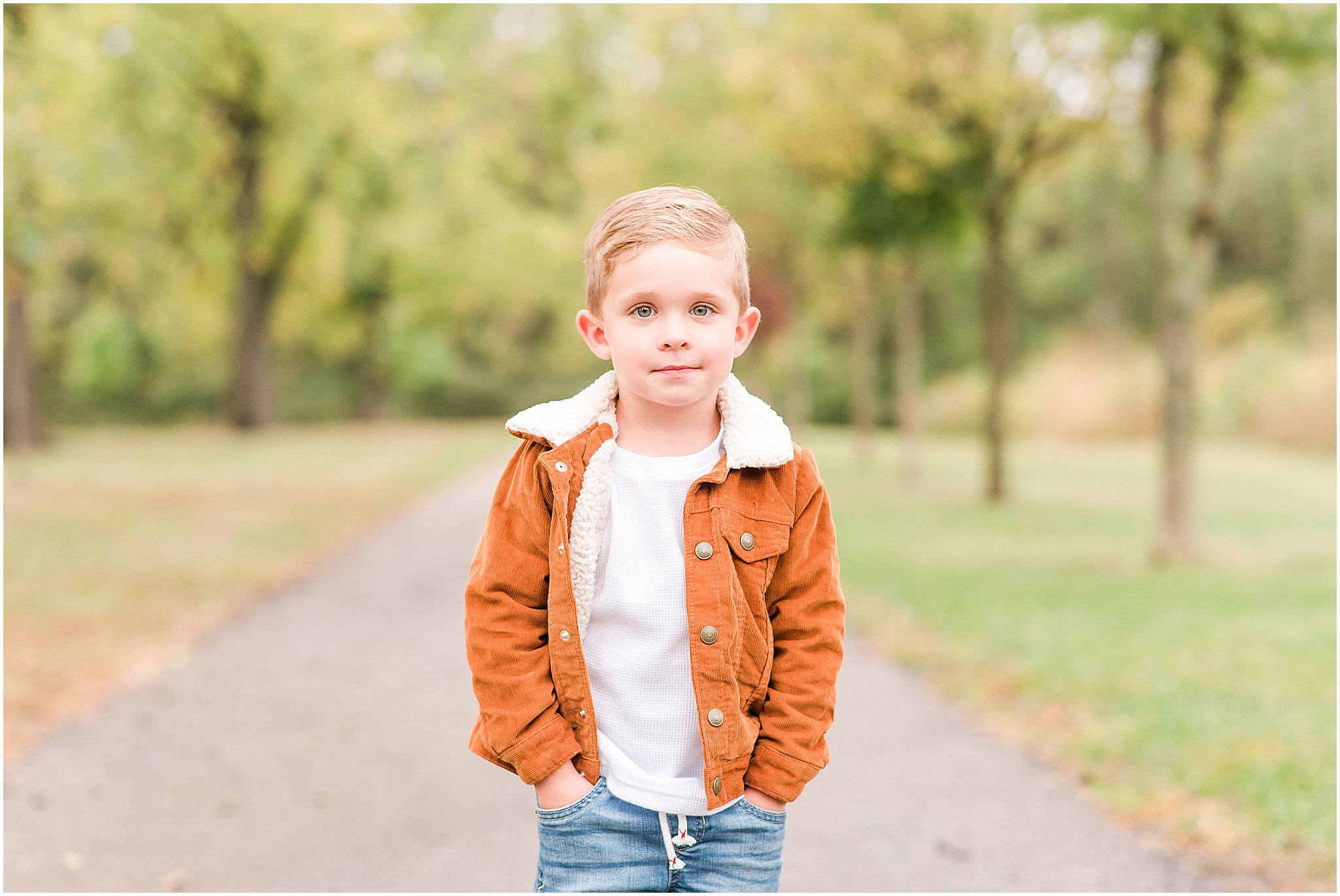 Toddler boy with hands in pockets smiling at camera during Southeastway Park family session