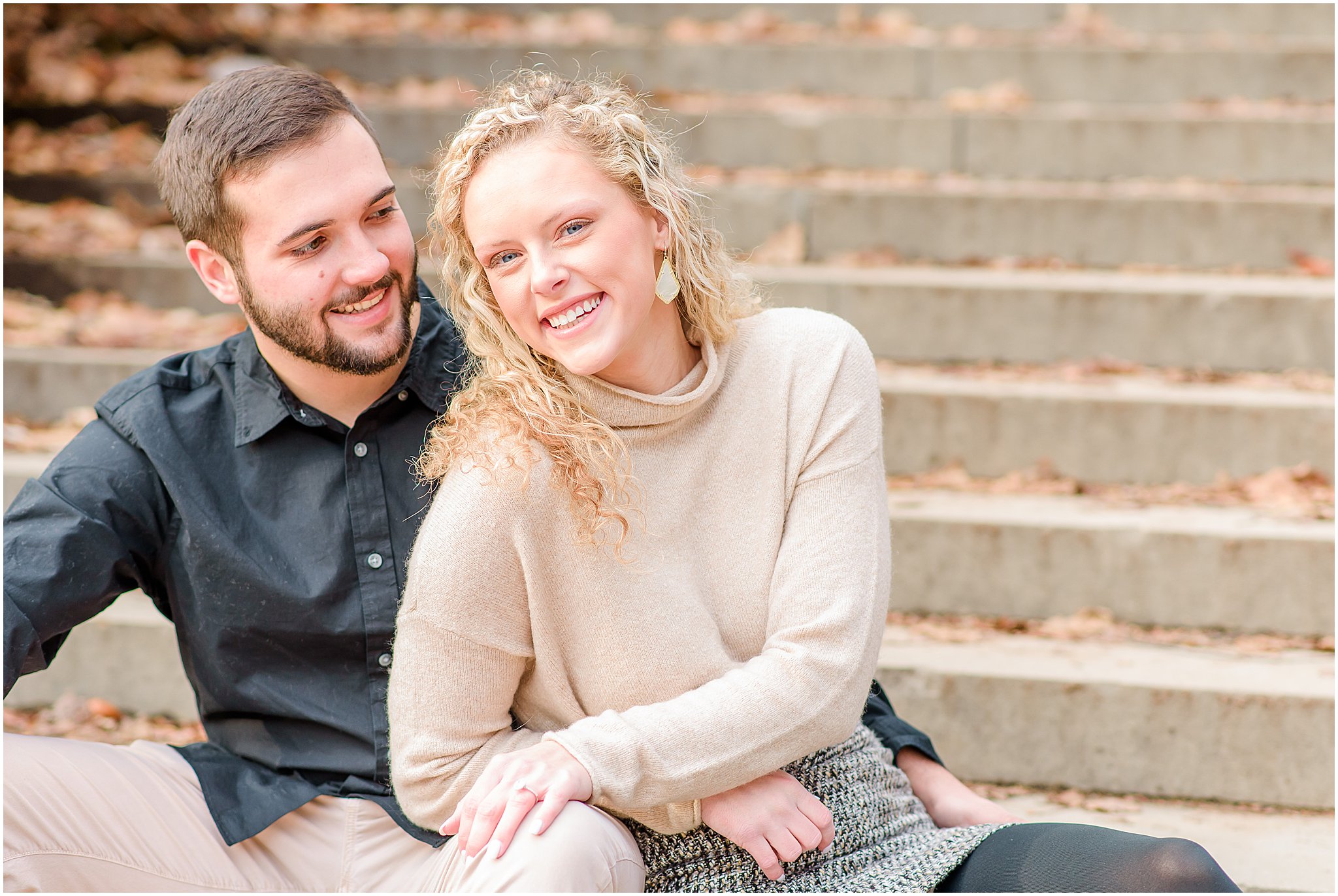 Couple smiling and sitting on steps during Holcomb Gardens engagement session