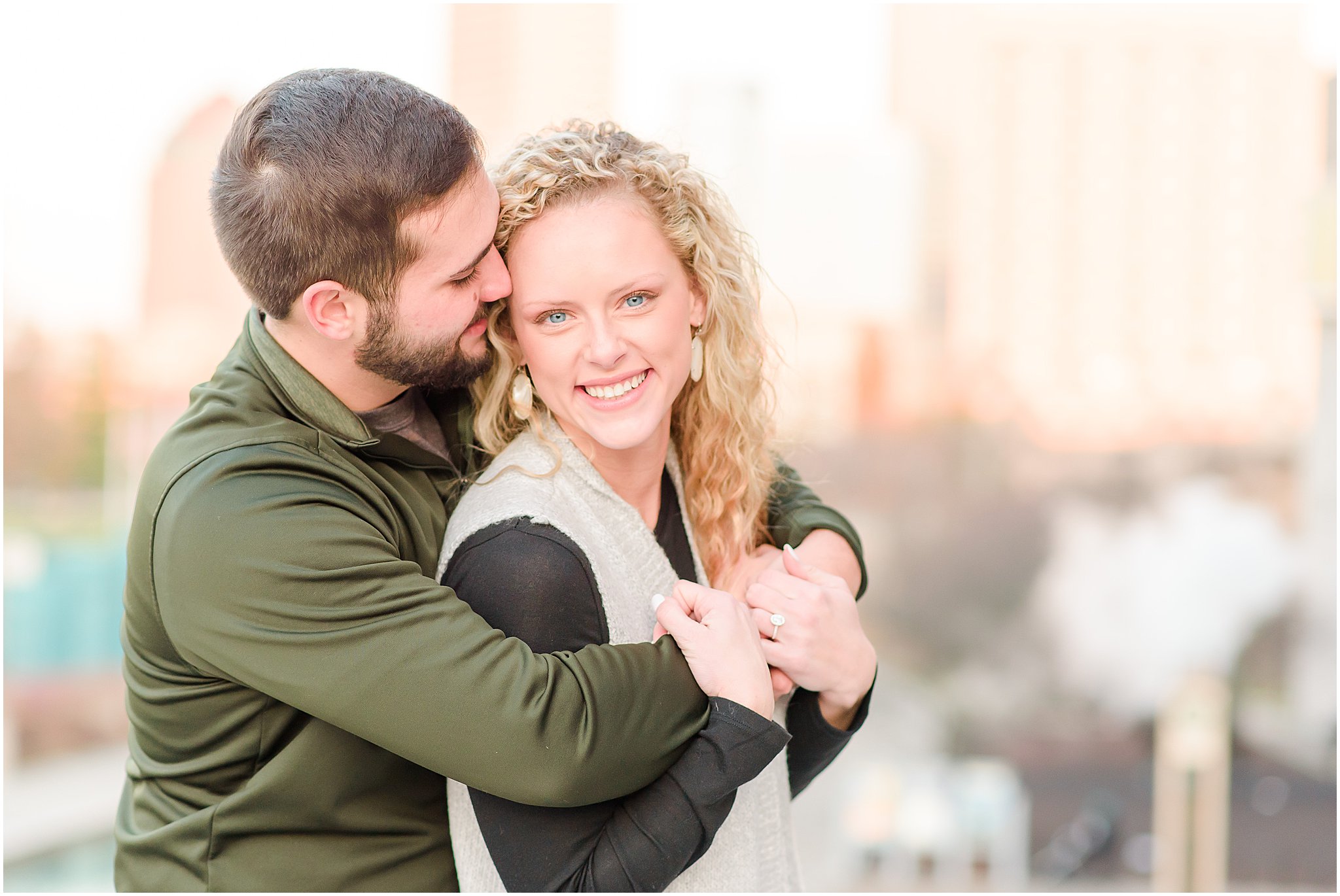 Couple nuzzling in front of Indianapolis skyline during Indianapolis Canal Engagement Session