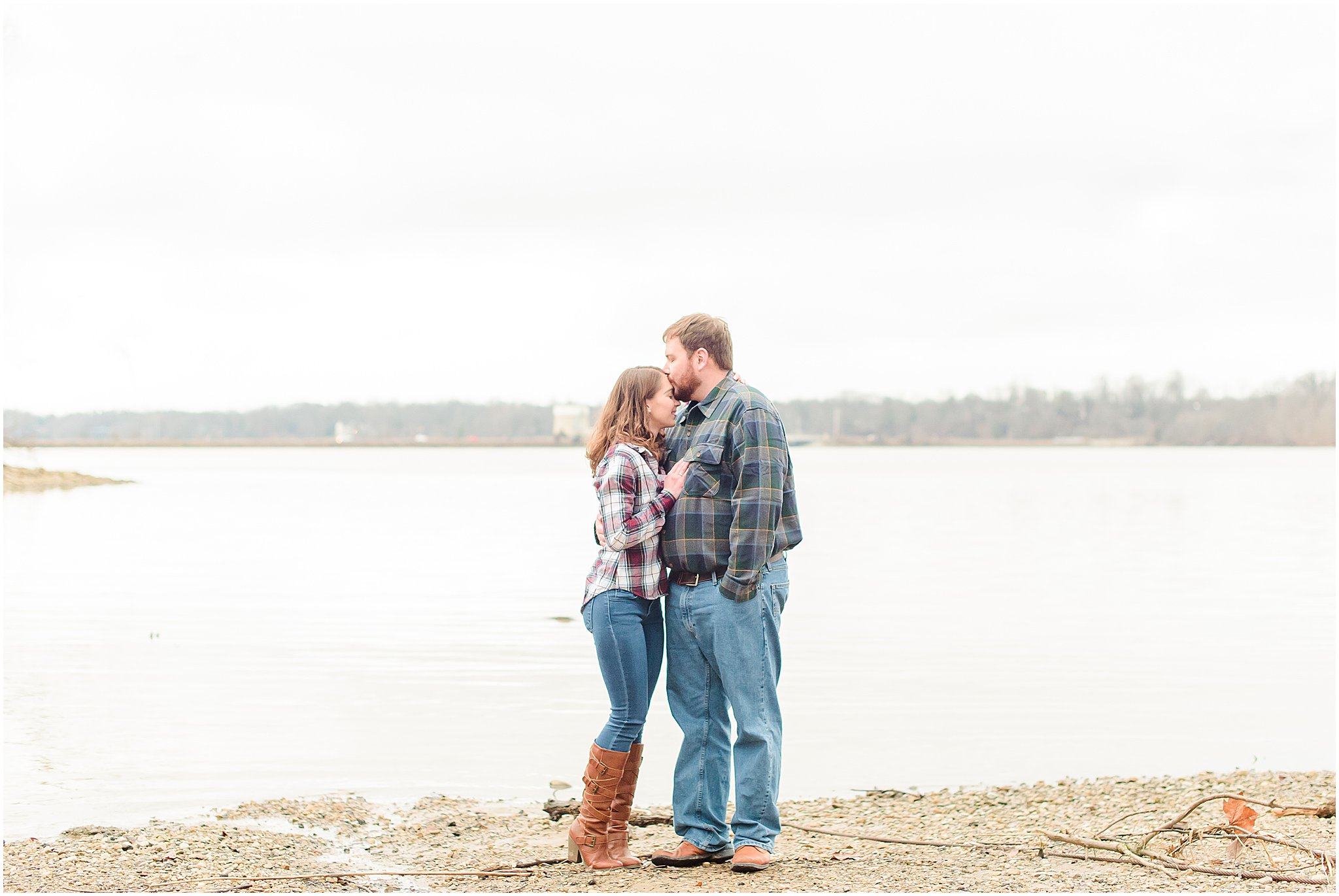 Couple kissing lakeside during Eagle Creek Park engagement session