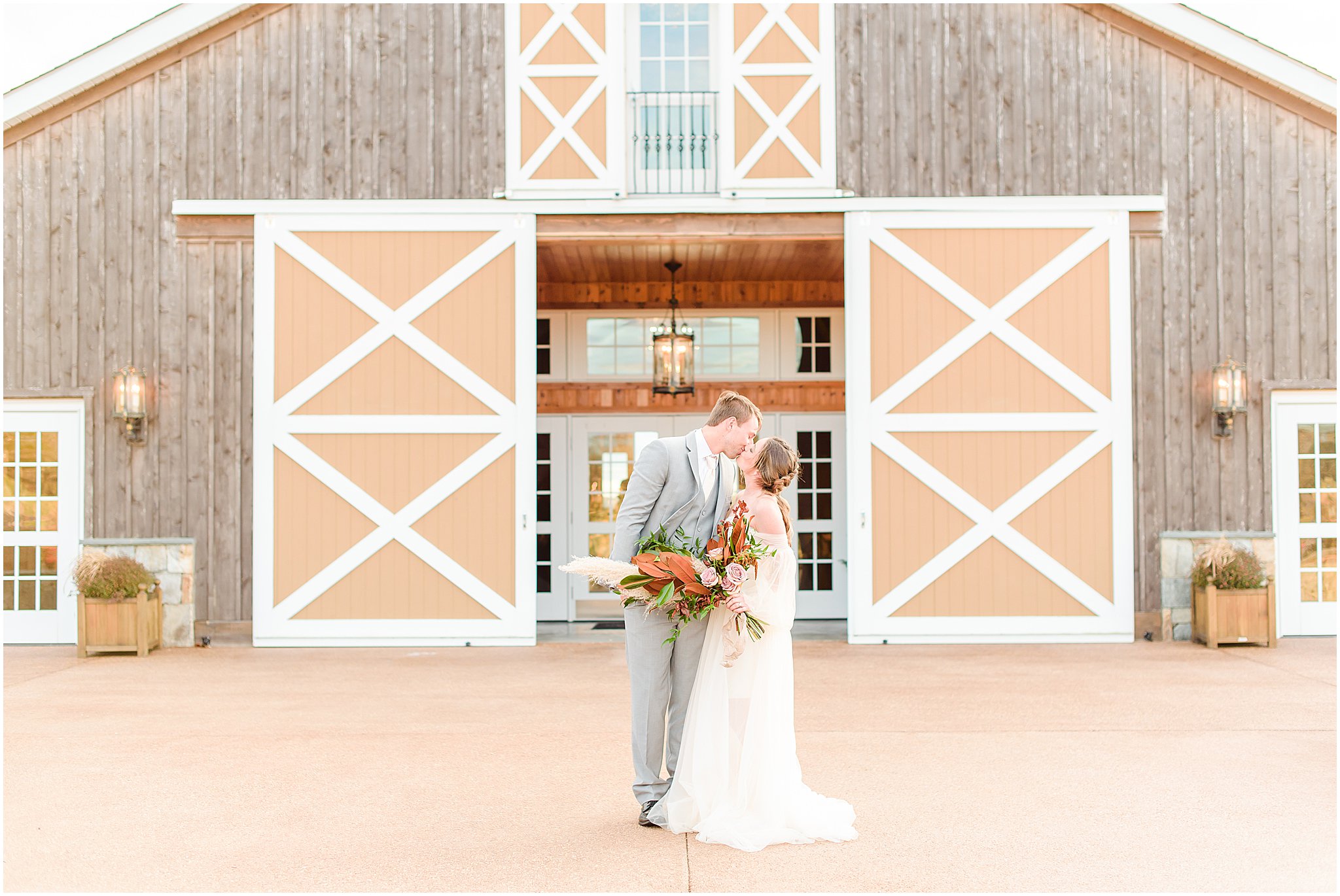 Bride and Groom kissing in front of The Lodge at Mount Ida Farm