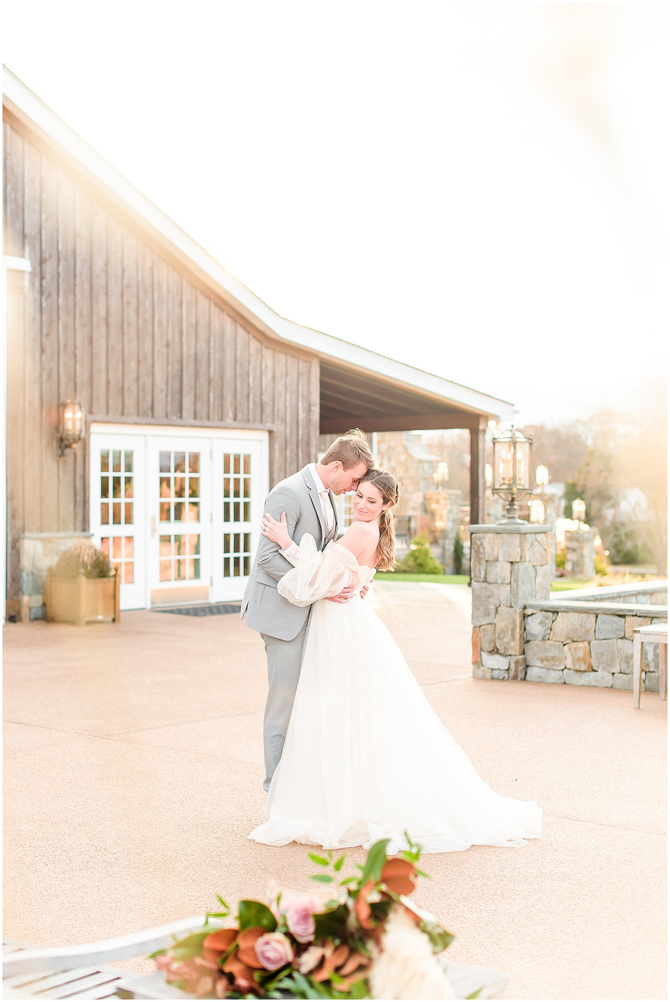 Bride and groom nuzzling in front of The Lodge Mount Ida Farm Wedding