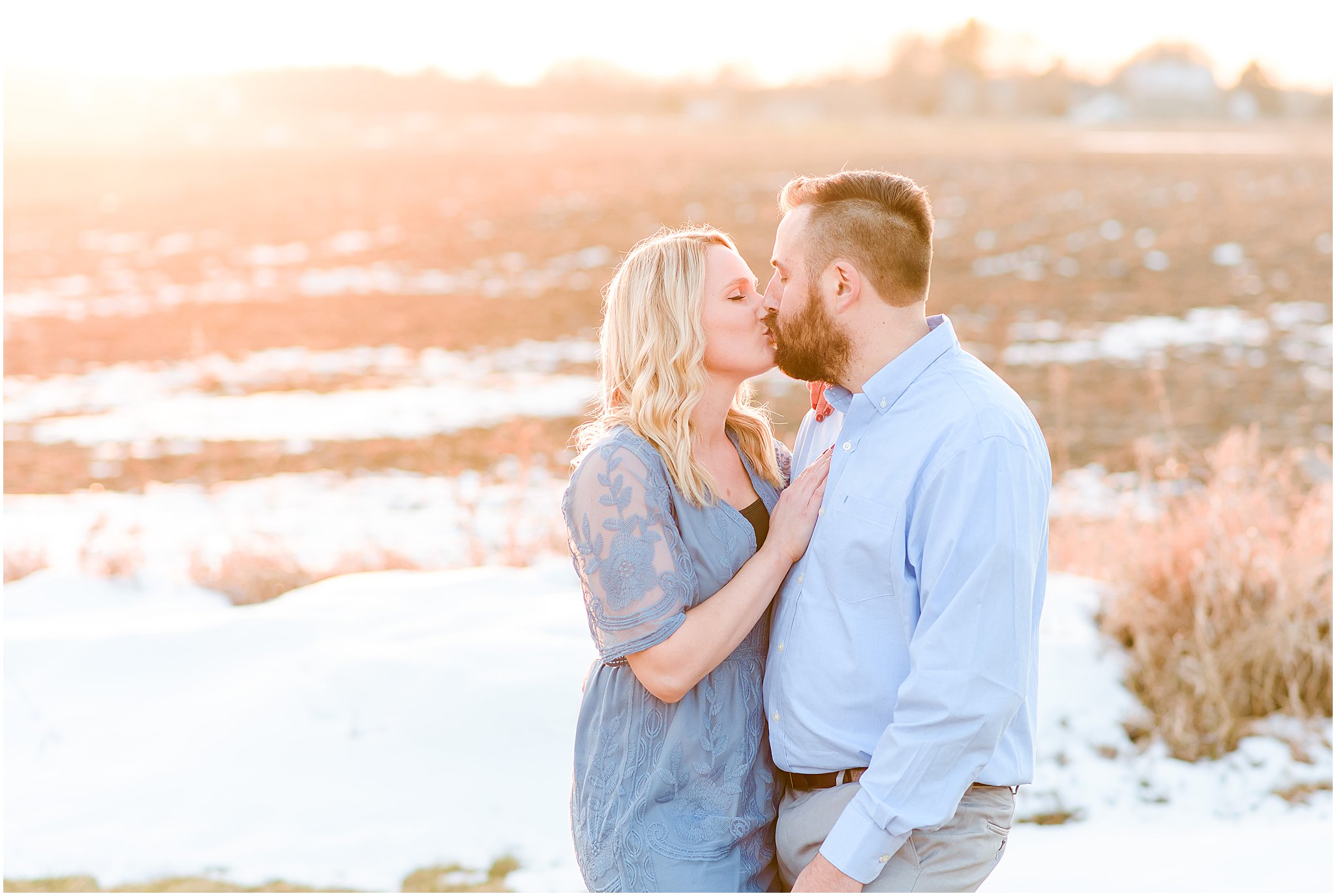 Couple kissing as they stand in the snow during sunset Lizton Lodge Engagement Session