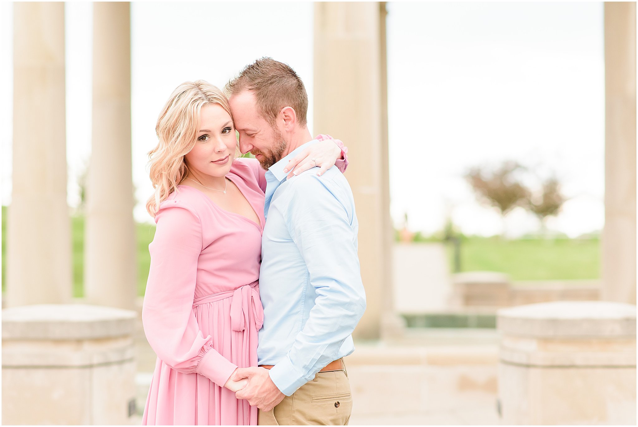 Couple nuzzling by gazebo during Coxhall Gardens engagement session