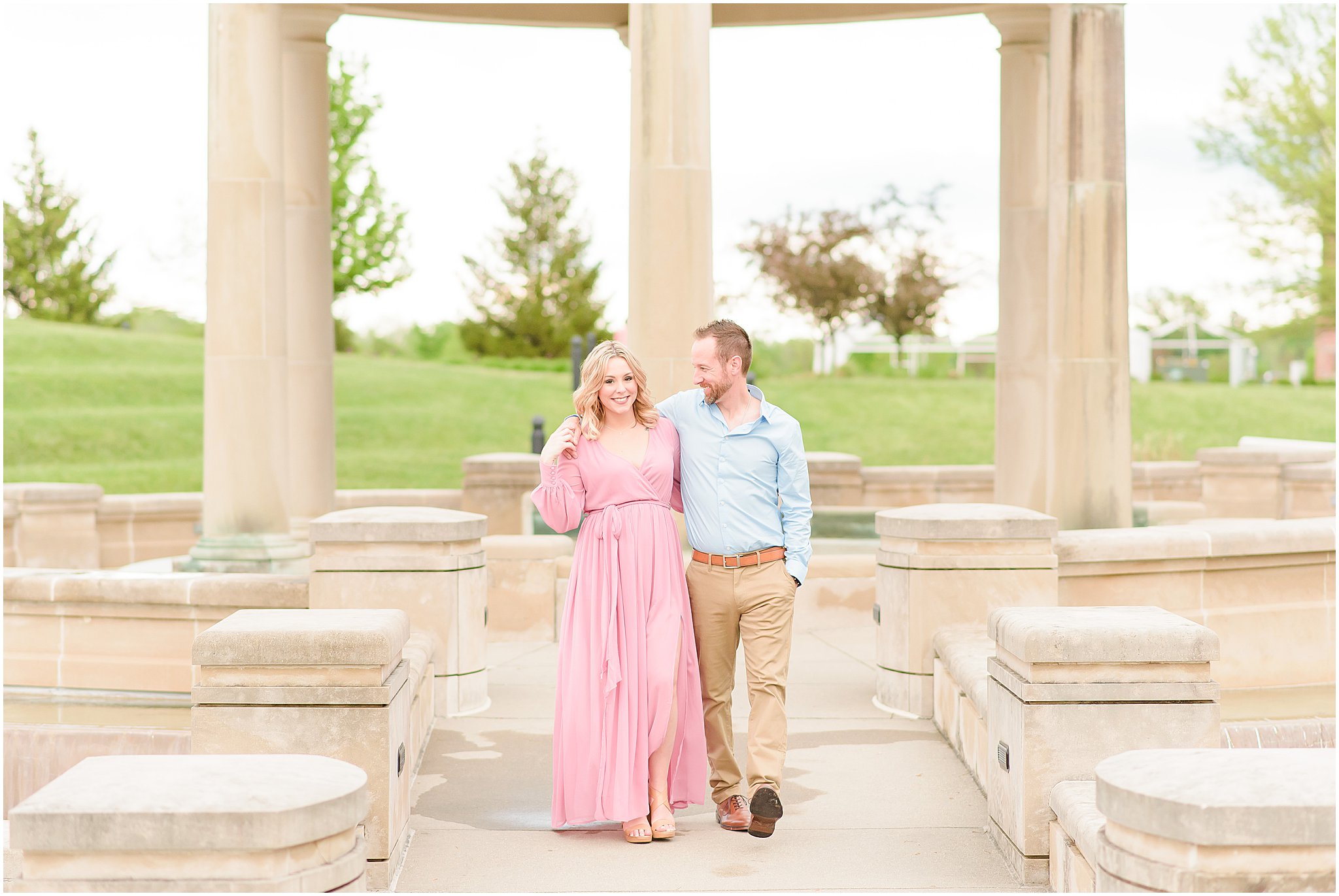 Couple laughing as hold hands and walking during Coxhall Gardens engagement session