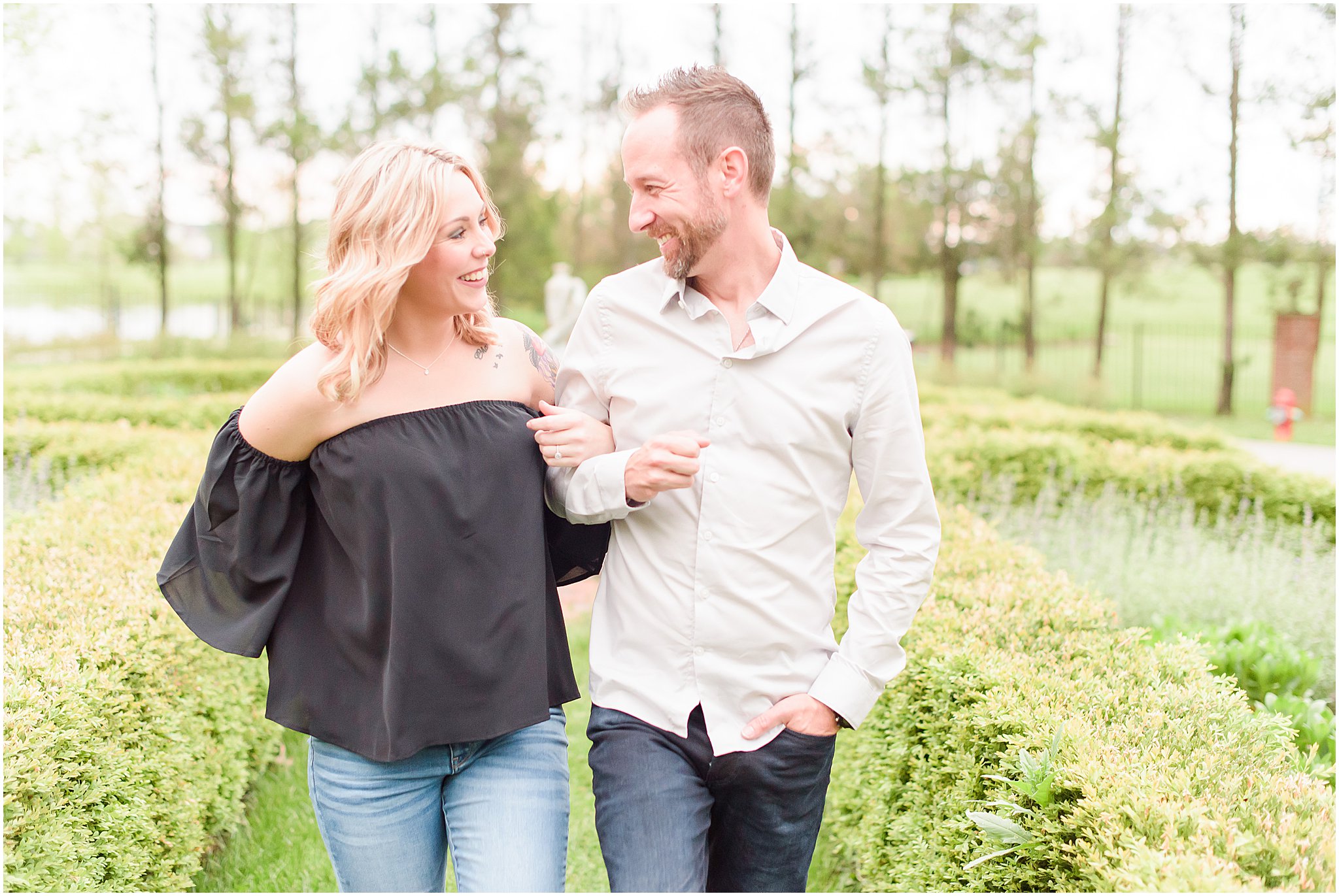 Couple laughing as they walk during Coxhall Gardens engagement session