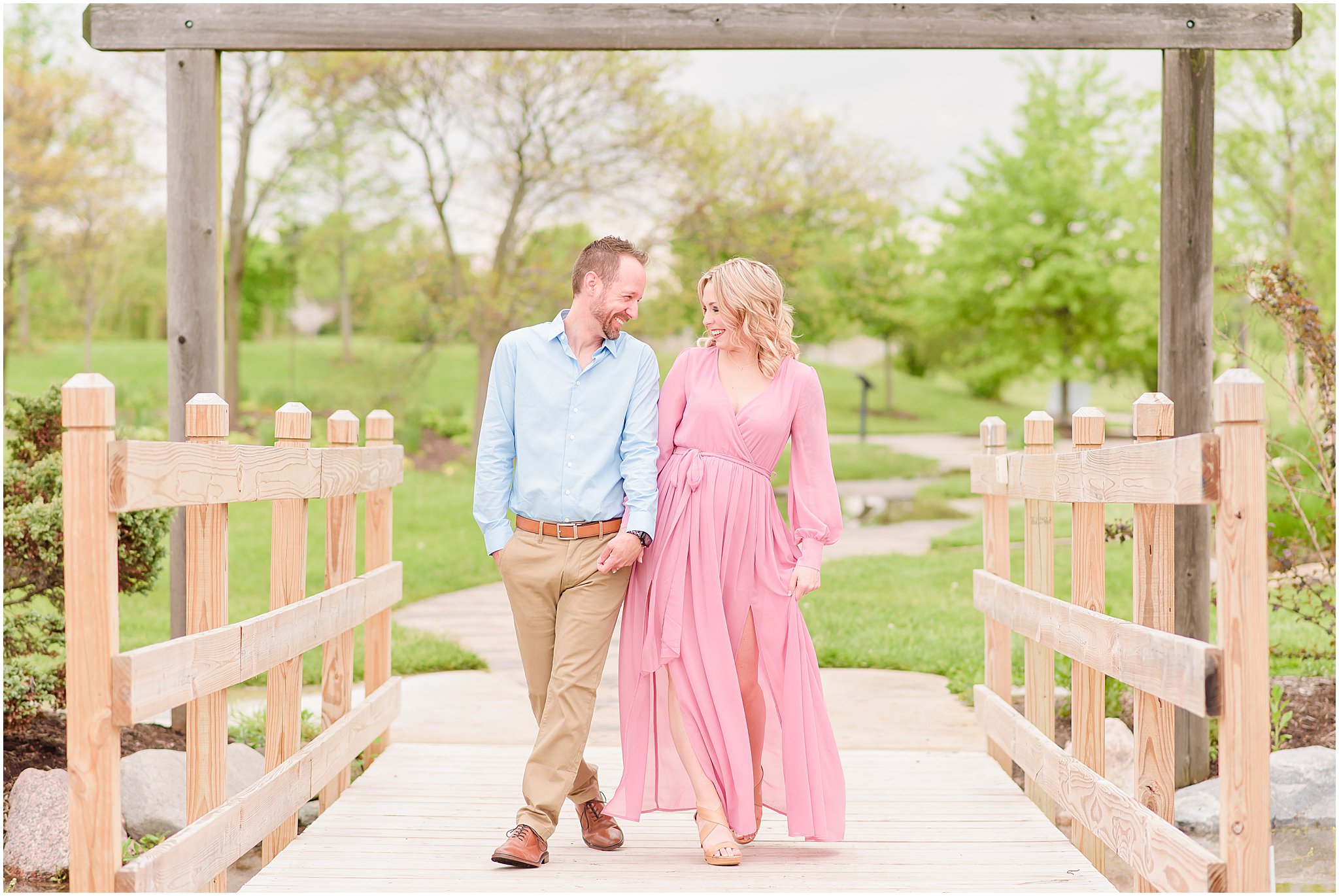 Couple laughing as hold hands and walking during Coxhall Gardens engagement session
