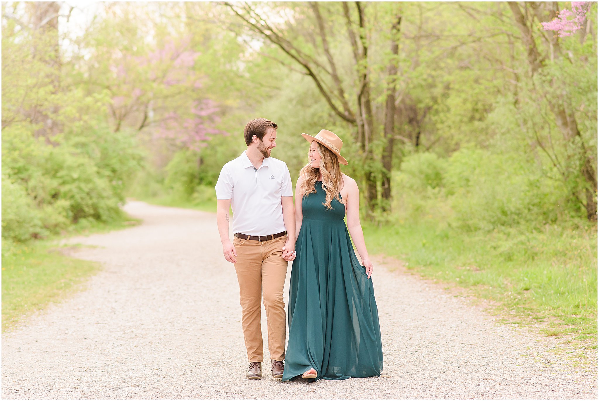 Couple strolling down path holding hands during Eagle Creek Park Engagement Session