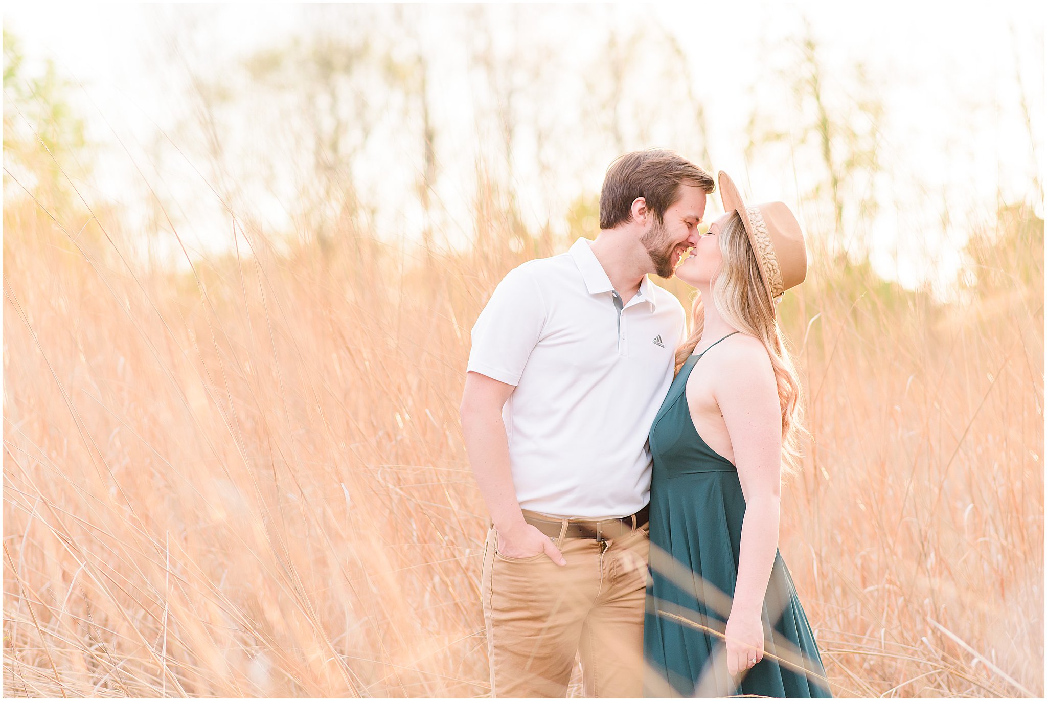 Couple kissing in sun-drenched field during Eagle Creek Park Engagement Session