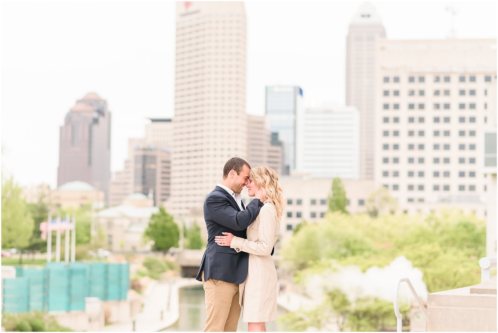 Couple nose to nose in front of Indy skyline during Indianapolis Canal engagement session 