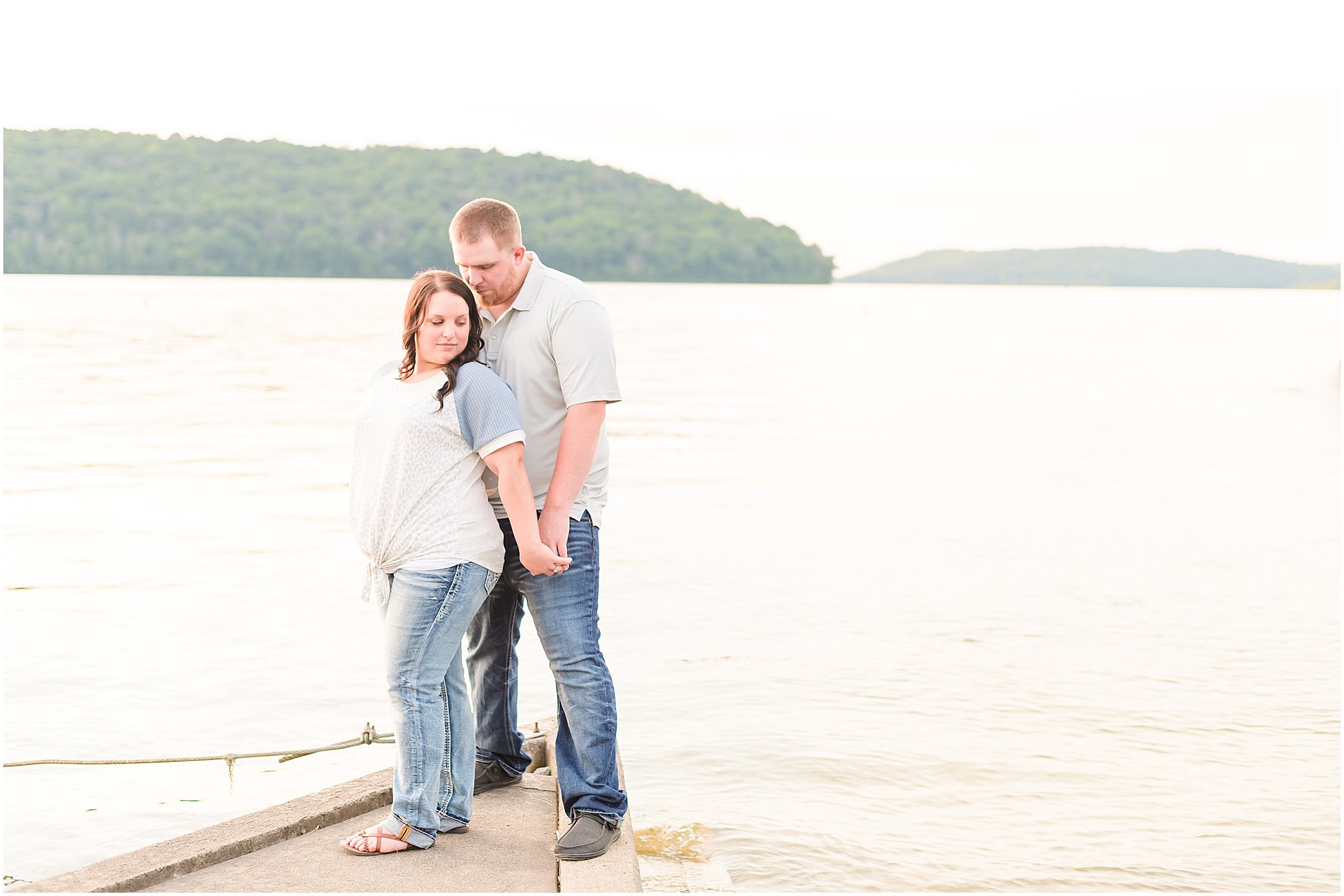 Couple nuzzling in front of the lake during Brookville Lake engagement session
