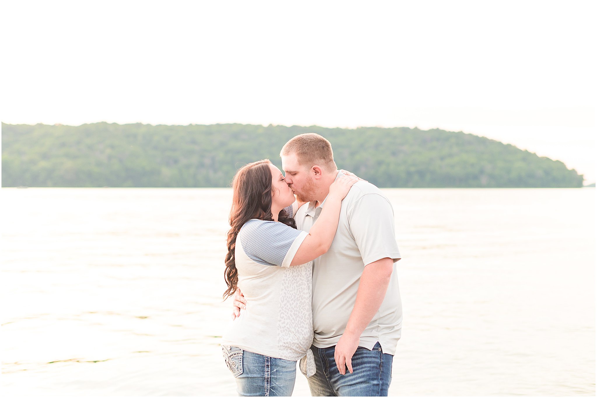 Couple kissing in front of the water during Brookville Lake engagement session