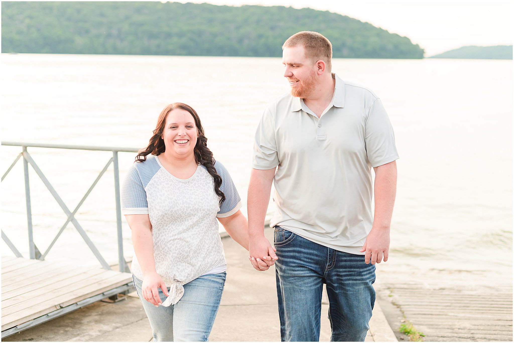 Couple holding hands and smiling during Brookville Lake engagement session