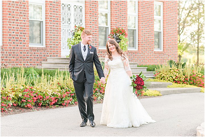 Bride and groom holding hands walking Coxhall Gardens anniversary session