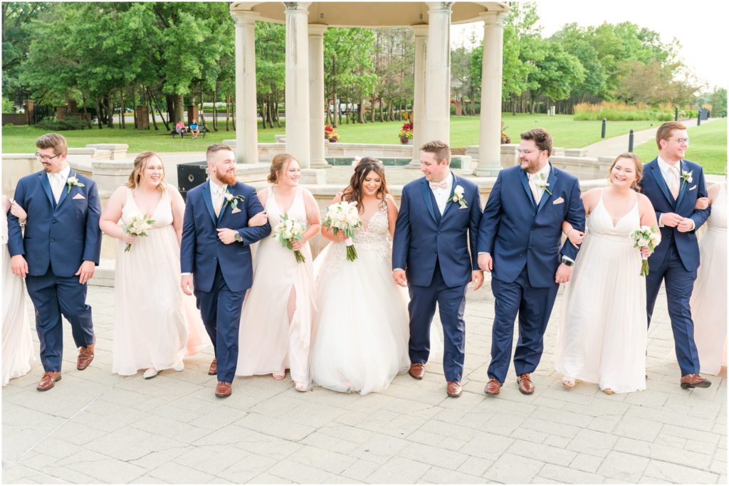 Bridal party walking and laughing Coxhall Gardens summer wedding