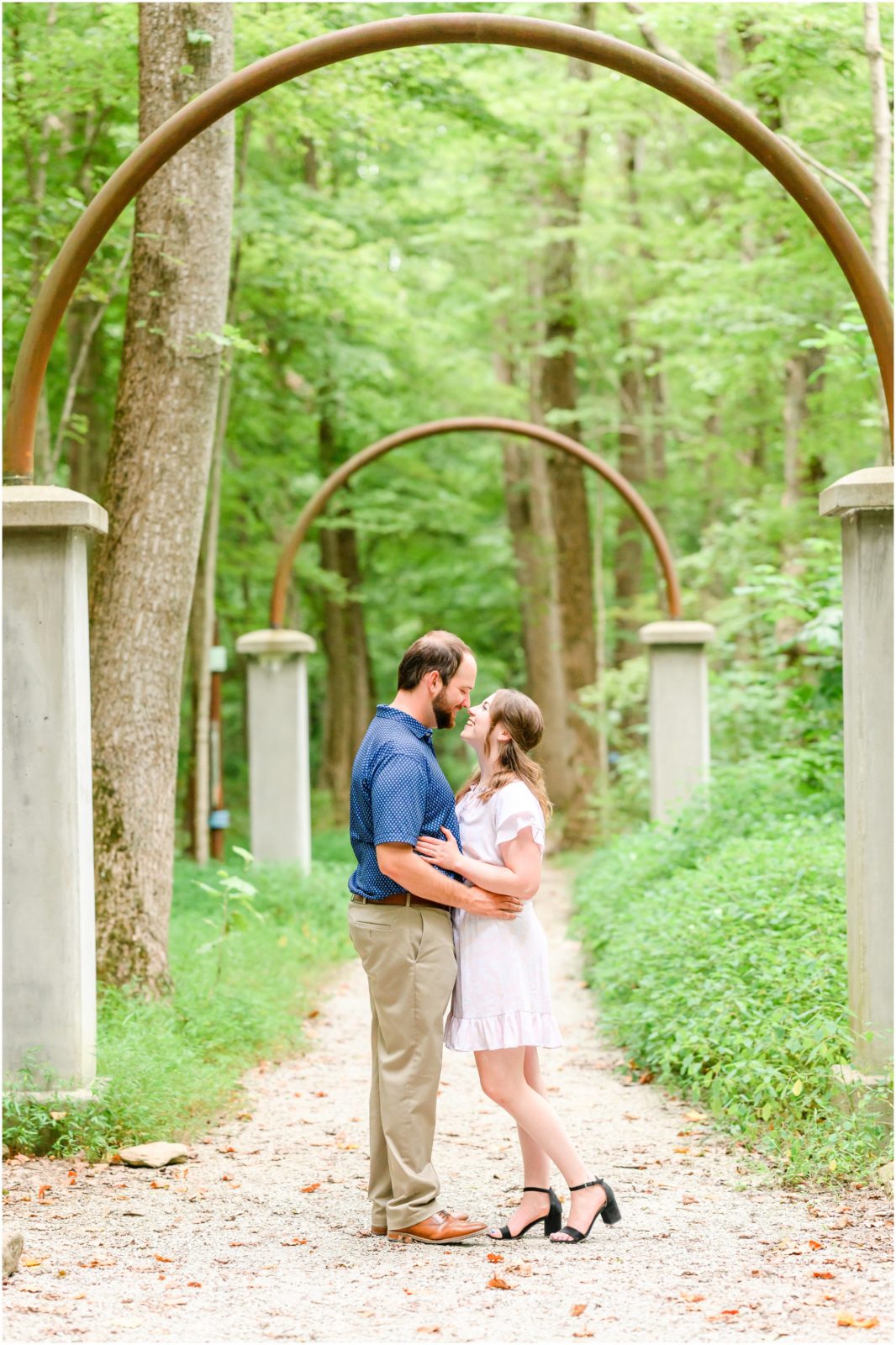 Couple nose to nose under rose arches Charlestown State Park engagement session