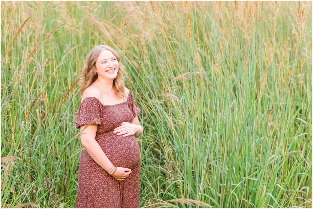 Mom holding baby belly and laughing Eagle Creek Park maternity session