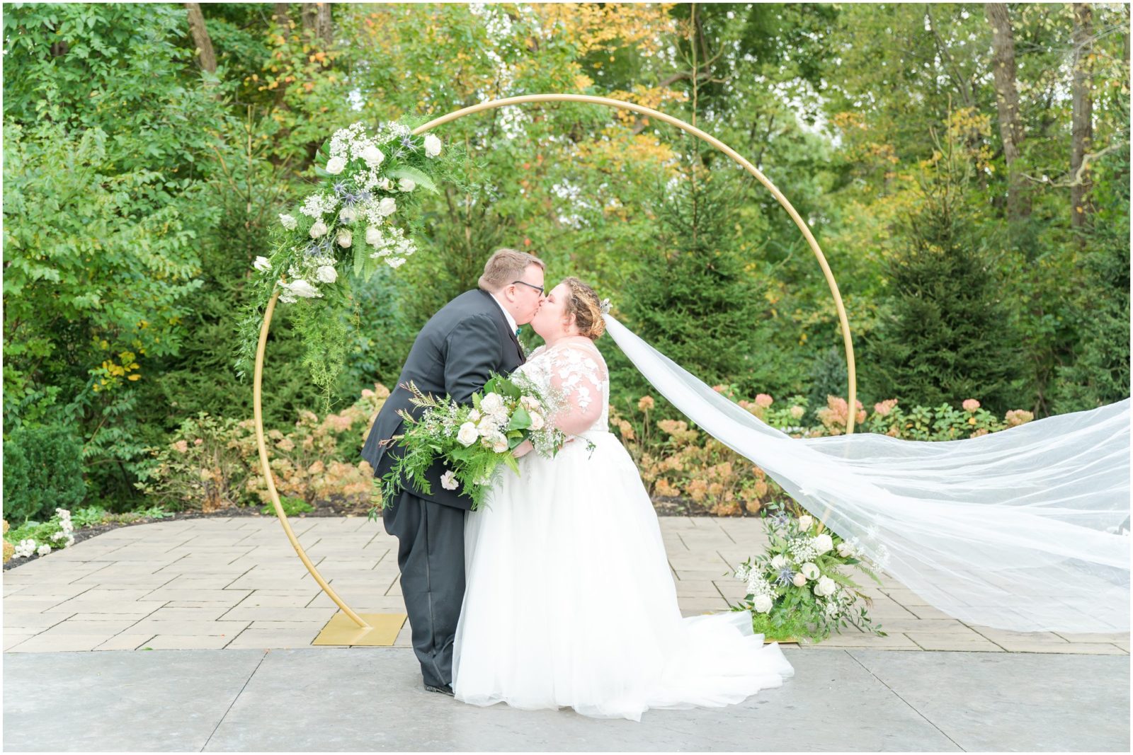 Dip kiss in front of floral arch Balmoral House wedding