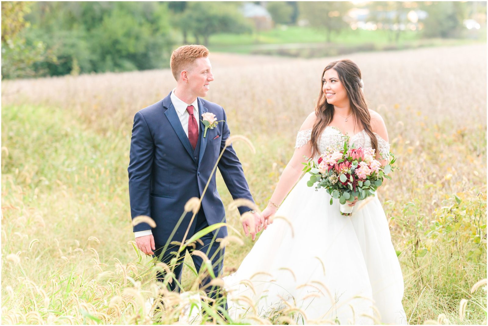 Bride and groom walking through field Mustard Seed Gardens wedding