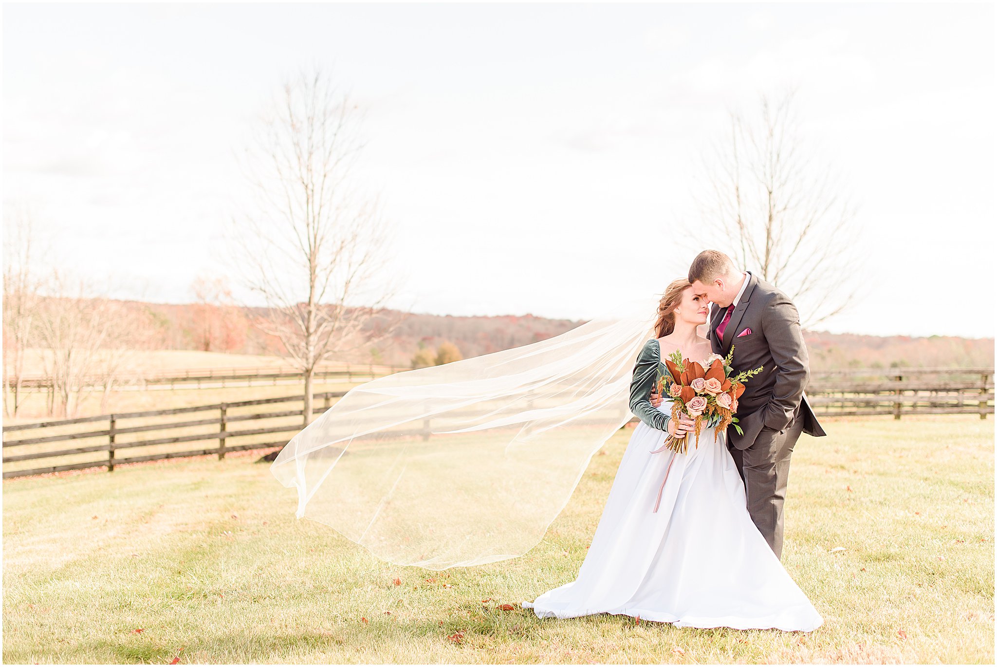 Bride and groom nuzzling with veil blowing in the wind Mount Ida Farm wedding