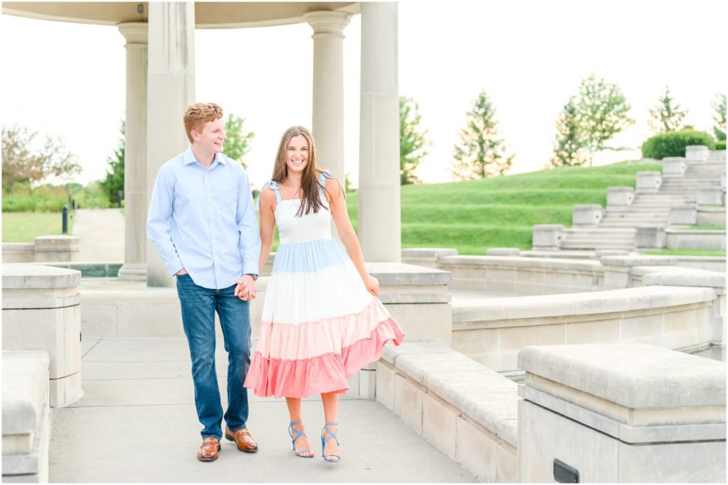 Couple holding hands and walking Coxhall Gardens engagement session